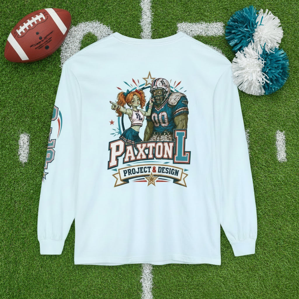 Blue long-sleeve t-shirt with a colorful graphic print on the front featuring a zombie football player and a zombie cheerleader with the text 'PAXTON L PROJECT & DESIGN'.