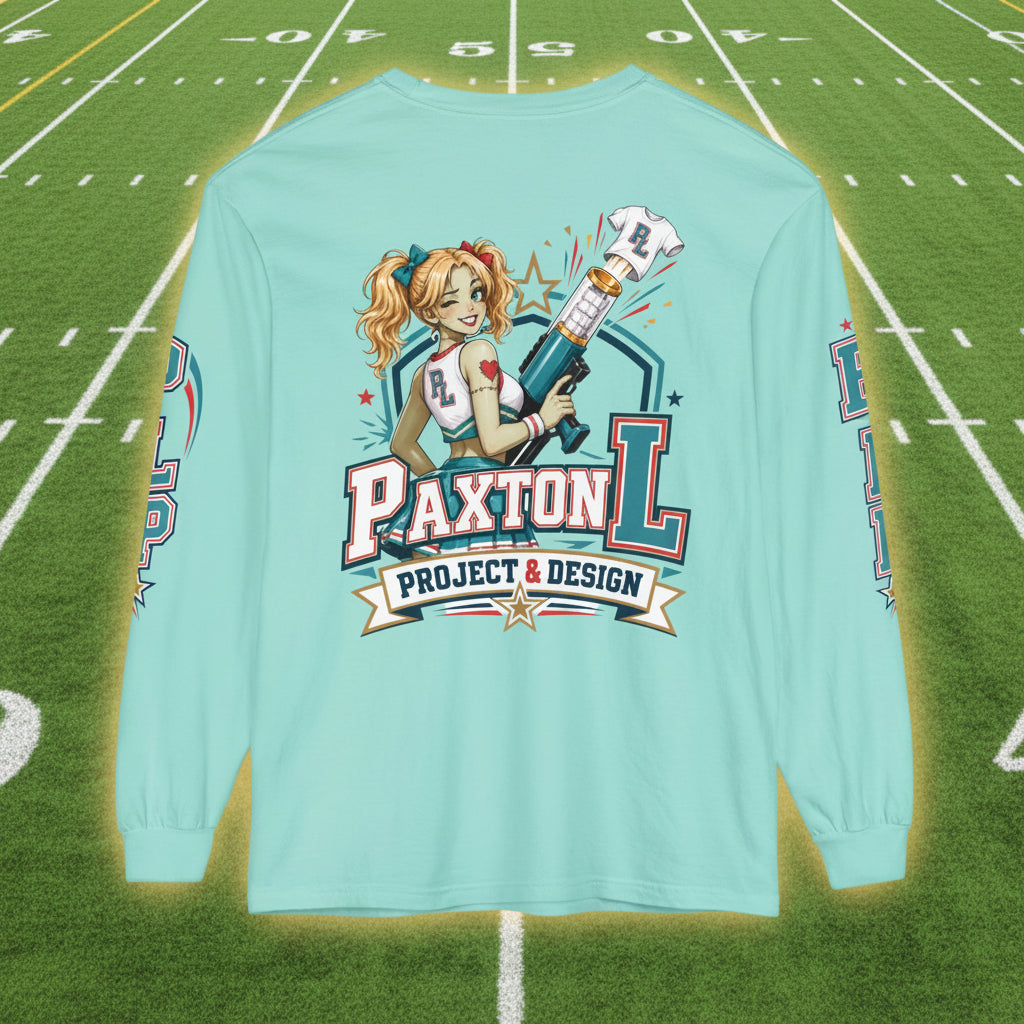 A light aqua long-sleeve t-shirt shown from the back, featuring a large graphic print of a zombie cheerleader-style pin-up girl holding a shirt launcher, with the text 'PAXTON L PROJECT & DESIGN'.